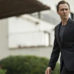 Hugh Laurie as Richard Roper appearing in the shadows during The Night Manager Season 2.